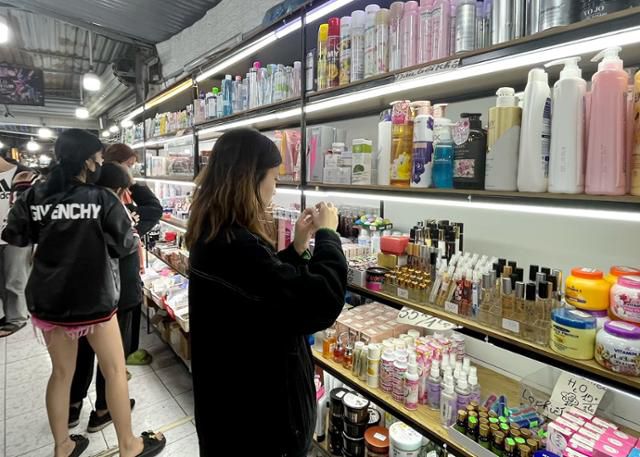 지난달 7일 베트남 하노이 풍꽝 시장에서 한 여성이 수입 화장품을 살피고 있다. 이곳에서 파는 화장품의 상당수는 가짜 제품, 이른바 '짝퉁'이다. 하노이=허경주 특파원