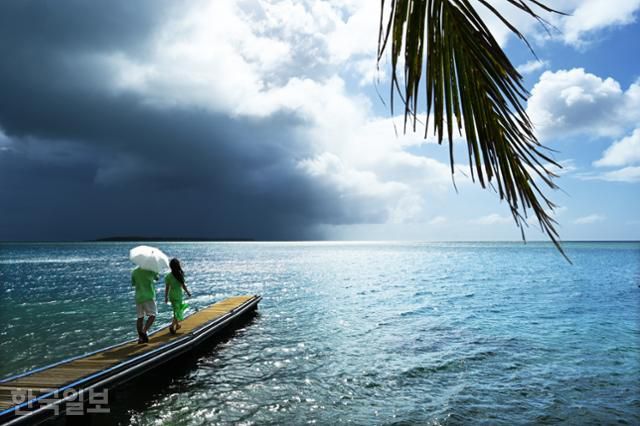 여행객이 인증사진을 찍기 위해 메리조 마을의 바다로 뻗은 선착장을 거닐고 있다.