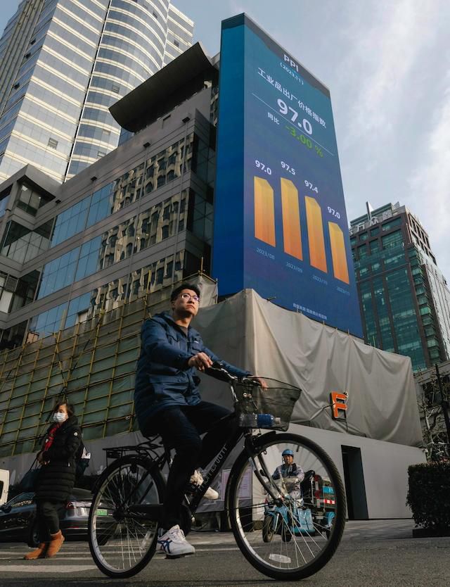 2일 새해 첫 증시 전광판 앞을 지나는 상하이 시민. 연합뉴스