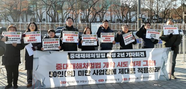 민주노총 관계자들이 지난 26일 오전 서울 용산구 대통령실 앞에서 중대재해처벌법 시행 2년 기자회견에서 중대재해처벌법 개악 시도 중단과 50인 미만 사업장의 적용을 촉구하는 구호를 외치고 있다. 뉴시스