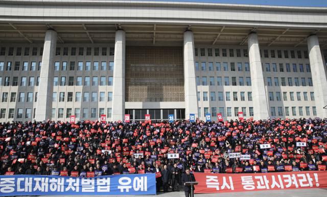 지난달 31일 오후 서울 여의도 국회 본청 앞 계단에서 열린 중대재해처벌법 유예 촉구 전국 중소기업인 결의대회에서 참가자들이 법안 유예를 촉구하는 피켓을 들고 있다. 뉴스1