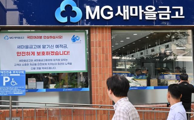 지난해 7월 새마을금고 '뱅크런'(대규모 예금 인출) 사태가 터졌을 당시 서울의 한 금고에 걸려 있는 안내문을 시민들이 읽고 있다. 왕태석 선임기자