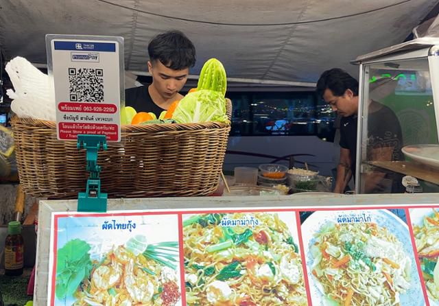 10일 태국 방콕 노점에 결제 시 사용하는 QR코드 종이가 비치돼 있다. 휴대폰 앱을 댄 뒤 비밀번호를 누르면 결제가 완료된다. 방콕=허경주 특파원