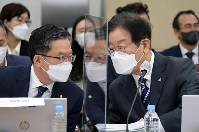 이재명(오른쪽) 더불어민주당 대표가 2022년 10월 4일 서울 용산구 국방부에서 진행된 국회 국방위원회 국정감사장에서 정성호 의원과 대화하고 있다. 한국일보 자료사진