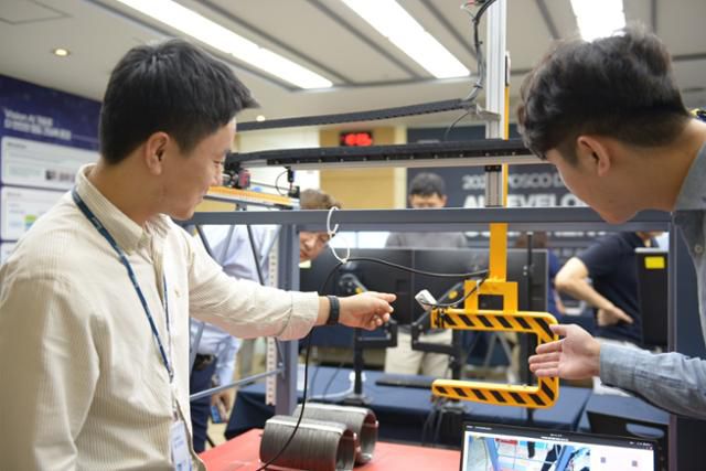 포스코DX AI기술센터 연구원들이 산업용AI가 적용된 크레인 모의장치를 시연하고 있다. 포스코DX 제공