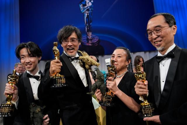 일본 영화 '고질라 마이너스 원'의 특수효과팀이 아카데미 특수효과상을 받은 후 고질라 모형과 트로피를 함께 들고 기뻐하고 있다. 로스앤젤레스=AP 연합뉴스