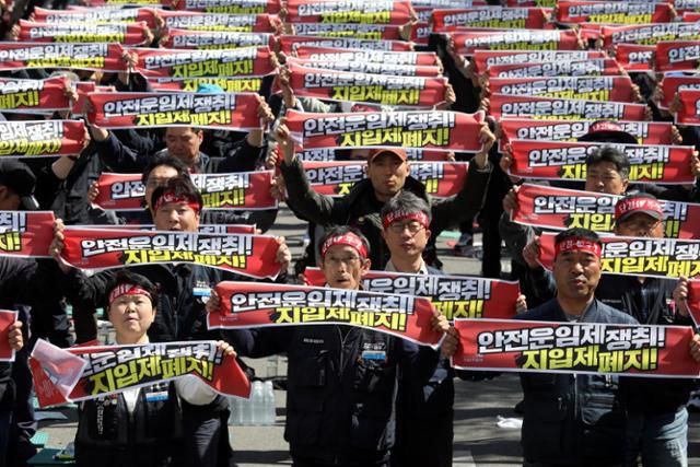 지난해 4월 8일 국회 앞에서 열린 화물노동자 결의대회에서 이봉주(앞줄 가운데) 화물연대 위원장을 비롯한 조합원들이 안전운임제 확대와 완전한 지입제 폐지 등을 촉구하는 구호를 외치고 있다. 뉴시스