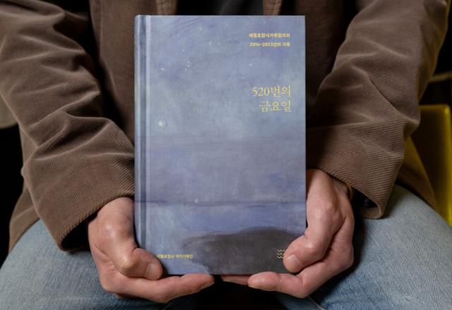 세월호참사 작가기록단의 강곤 작가가 책 '520번의 금요일'을 들어 보이고 있다. 박시몬 기자
