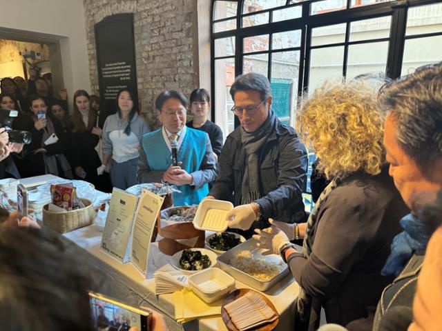 18일(현지시간) 이탈리아 베니스 일 지아르디노 비안코 아트 스페이스에서 열린 광주비엔날레재단 30주년 기념 아카이브 특별전 '마당-우리가 되는 곳' 개막식에서 정병국 문예위 위원장이 강기정 광주시장과 함께 내빈들에게 주먹밥을 만들어 대접하고 있다. 베네치아=이혜미 기자