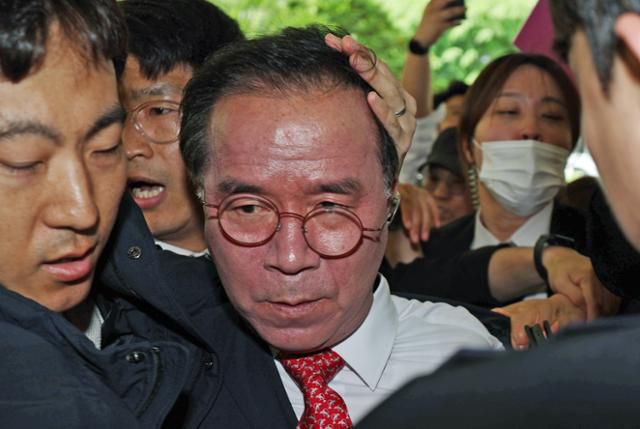 이태원참사 부실 대응 혐의로 재판에 넘겨진 김광호(왼쪽 세 번째) 전 서울경찰청장이 지난달 22일 오후 서울 마포구 서부지법에서 유가족들에게 거센 항의를 받으며 첫 공판에 출석하고 있다. 뉴스1