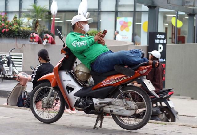 지난달 30일 베트남 하노이 그랩 바이크 기사 호앙타잉떠가 오토바이 위에서 휴식을 취하고 있다. 하노이=허경주 기자