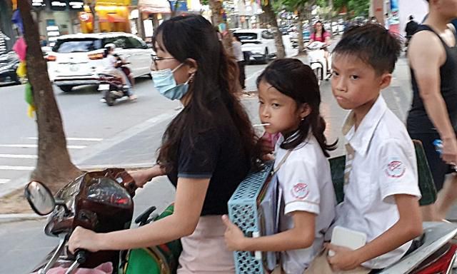 지난달 31일 베트남 하노이에서 남매가 엄마가 운전하는 오토바이를 타고 하교하고 있다. 한 오토바이에 3, 4명이 탑승하는 일은 흔하다. 아이들의 뒤로 인도 위를 달리는 또 다른 오토바이도 보인다. 하노이=허경주 특파원