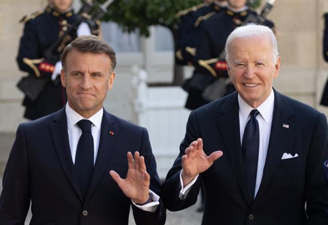 에마뉘엘 마크롱(왼쪽) 프랑스 대통령이 8일 국빈 자격으로 프랑스를 방문한 조 바이든 미국 대통령과 함께 프랑스 파리 엘리제궁에 들어서며 손 인사를 하고 있다. 파리=UPI 연합뉴스