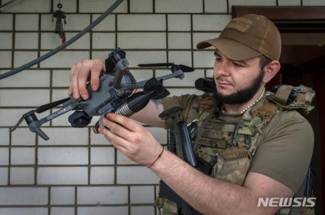 우크라이나 도네츠크 외곽 전선에서 한 우크라이나 군인이 드론에 폭탄을 장착하고 있다. AP 뉴시스