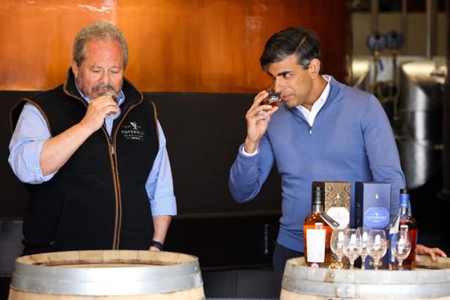 영국 보수당 대표인 리시 수낵(오른쪽) 영국 총리가 1일 영국 중부 위치퍼드에 있는 코츠월드 증류소에서 이곳의 설립자인 댄 조르와 함께 위스키 향을 맡고 있다. 위치퍼드=AFP 연합뉴스