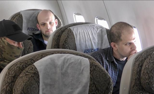 미국 월스트리트저널(WSJ) 기자인 에반 게르시코비치(첫쨰줄 오른쪽)이 1일 러시아 감옥에서 풀려나 비행기를 통해 미국으로 이동하고 있다. 러시아 정보당국이 제공한 영상 일부를 캡처한 사진이다. EPA 연합뉴스