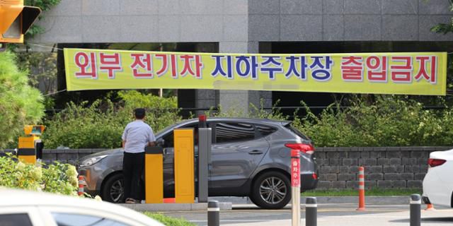 12일 서울 시내 한 아파트에 외부 전기차 지하주차장 출입금지 현수막이 걸려 있다. 서울시는 최근 아파트 등에서 전기차 화재가 잇따르자 완충차량 지하주차장 출입금지 등의 대책을 추진하고 있다. 연합뉴스