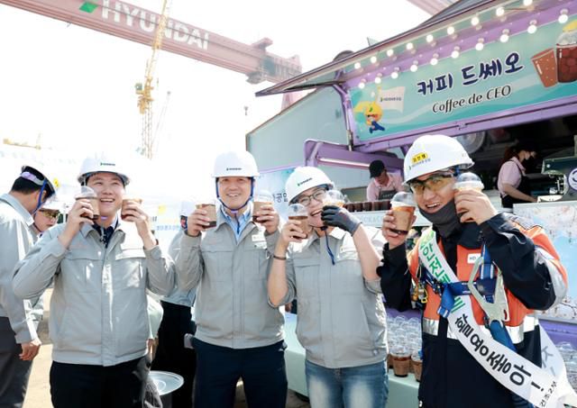 HD현대중공업 울산 조선소 근로자들이 최근 회사 측이 운영하는 찾아가는 푸드트럭에서 아이스 커피를 받아든 뒤 함박웃음을 짓고 있다. HD현대중공업 제공