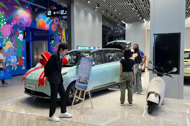 지난달 20일 태국 방콕의 한 대형 쇼핑몰에서 한 시민이 중국 광저우자동차그룹 전기차 자회사 아이온(AION) 차량 안내판을 읽고 있다. 방콕=허경주 특파원