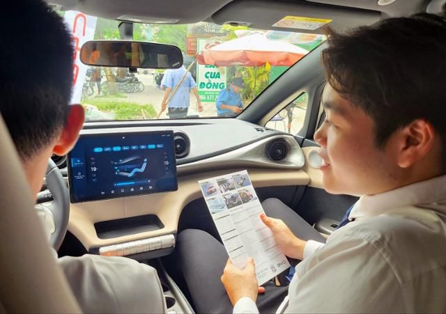 지난 24일 베트남 하노이의 중국 전기차 회사 비야디(BYD) 대리점에서 직원이 시승에 나선 시민에게 기능을 설명하고 있다. 하노이=허경주 특파원