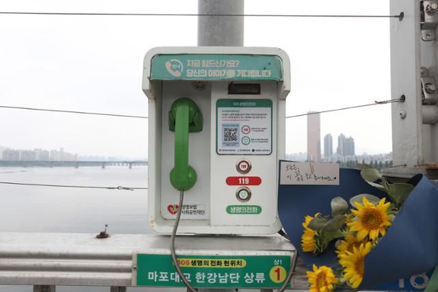 세계 자살예방의날인 9월 10일 서울 마포대교에 설치된 생명의 전화 옆에 꽃다발이 놓여져 있다. 뉴스1