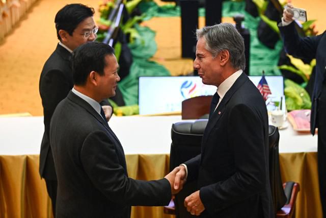 토니 블링컨(오른쪽) 미국 국무장관이 11일 라오스 비엔티안에서 열린 미국과 동남아시아국가연합(ASEAN·아세안) 정상 간 회의 입장에 앞서 훈마넷(왼쪽) 캄보디아 총리와 악수하고 있다. 비엔티안=AFP 연합뉴스