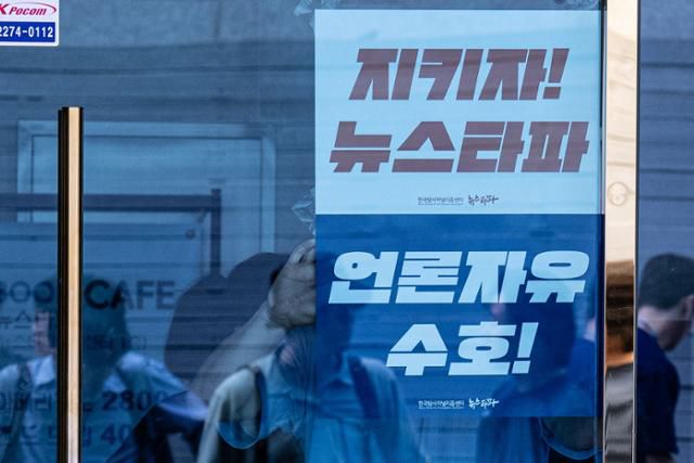 검찰이 윤석열 대통령 관련 문제로 독립언론 뉴스타파 압수수색 영장을 집행한 지난해 9월 14일 뉴스타파 관계자들이 서울 종로구 사옥 출입구에 수사를 규탄하는 인쇄물을 부착하고 있다. 이한호 기자