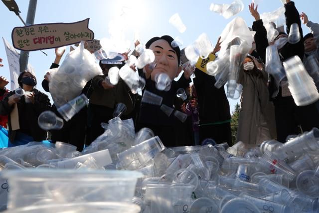 서울환경운동연합을 비롯한 환경시민단체 회원들이 지난 2022년 10월 18일 서울 용산구 대통령실 앞에서 일회용컵 보증금제 무력화하는 윤석열 정부를 규탄하는 퍼포먼스를 하고 있다. 환경부는 24일 보증금제 시행을 각 지방자치단체 자율에 맡기고, 점진적 단계적으로 전국 시행을 할 계획이라고 밝혔다. 핵심은 '강제는 없다'는 것이다. 뉴시스