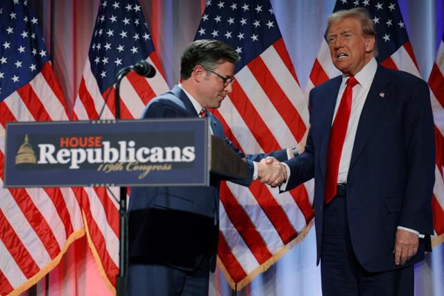 도널드 트럼프(오른쪽) 미국 대통령 당선자가 13일 하원 공화당 의원들이 모인 워싱턴의 한 호텔에서 마이크 존슨 하원의장과 만나 악수하고 있다. 워싱턴=로이터 연합뉴스