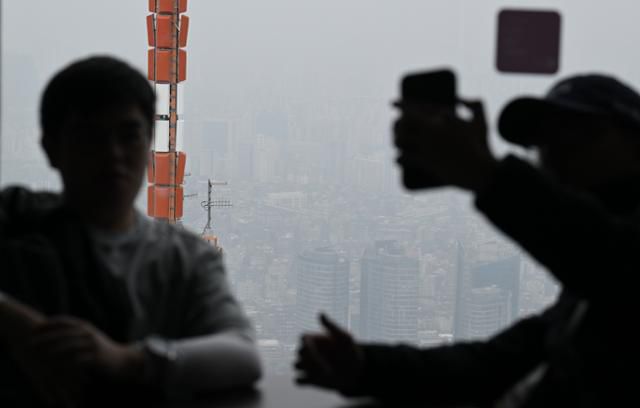 21일 서울 용산구 N서울타워 전망대에서 관광객들이 미세먼지 가득한 도심을 바라보고 있다. 이날 종일 수도권과 충청, 경북지역에 초미세먼지 농도가 '나쁨' 수준까지 높을 것으로 예보됐다. 최주연 기자