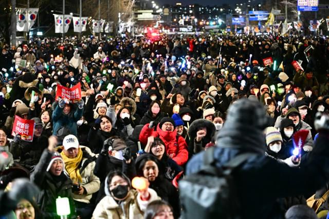 국민의힘 의원들이 7일 윤석열 대통령에 대한 탄학소추안 국회 본회의 표결을 앞두고 퇴정하자 서울 여의도 국회대로 일대에 모인 시민들이 표결 참여를 촉구하고 있다. 이한호 기자
