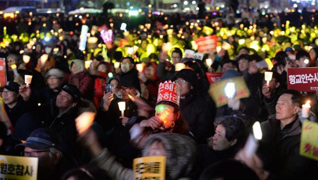 2017년 3월 헌법재판소의 박근혜 전 대통령 탄핵 인용 결정을 환호하는 시민들이 서울 광화문 광장에서 열린 촛불집회에서 촛불을 들고 자축하고 있다. 류효진 기자