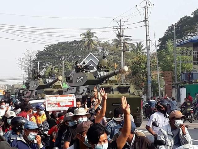2021년 2월 미얀마 양곤에서 북쪽으로 3시간 거리인 따웅우에 등장한 장갑차 앞에서 시민들이 저항을 상징하는 세 손가락을 들어올리며 항의하고 있다. 한국일보 자료사진