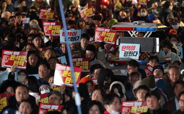 윤석열 대통령의 비상계엄 해제 요구 결의안이 국회 본회의에서 통과된 4일 새벽 서울 여의도 국회 정문 앞에 모인 시민들이 윤 대통령을 규탄하고 있다. 뉴스1