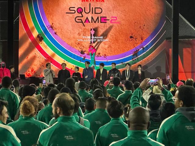 넷플릭스 '오징어 게임' 시리즈를 연출한 황동혁 감독과 이정재 등 오징어 게임 2 출연 배우들이 13일 미국 캘리포니아주 로스앤젤레스 시티칼리지에서 열린 오징어게임 팬이벤트에 참석해 참가자들에게 인사말을 하고 있다. 로스앤젤레스=이서희 특파원