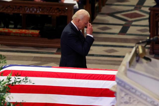 조 바이든 미국 대통령이 9일 미국 워싱턴 국립대성당에서 열린 지미 카터 전 미 대통령의 국가장례식 도중 관 옆에서 고인을 추모하고 있다. 워싱턴=로이터 연합뉴스
