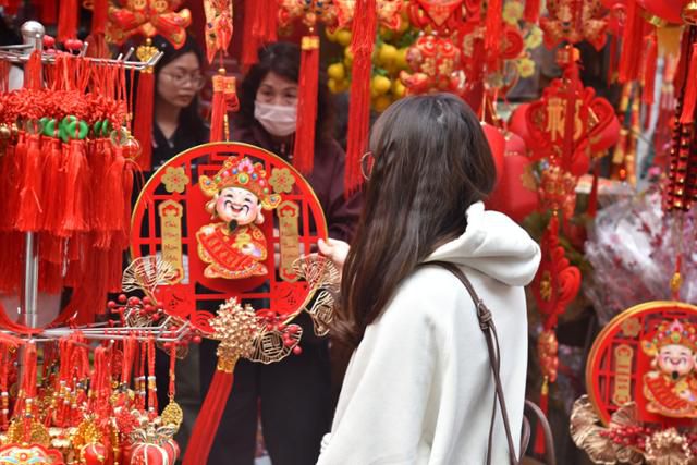 베트남 음력설 '뗏'을 앞둔 지난 17일 한 베트남 여성이 하노이 항마거리에서 설 장식품을 살피고 있다. 하노이=허경주 특파원