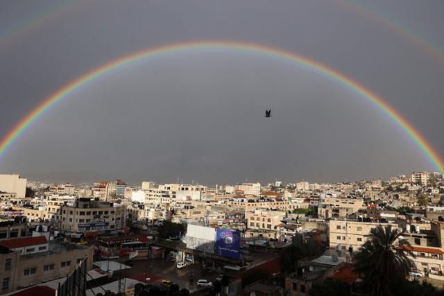 불안한 휴전을 이어가던 이스라엘과 팔레스타인 무장정파 하마스 앞에 다시 전운이 감돌고 있는 가운데 12일 요르단강 서안지구 제닌 상공에 쌍무지개가 떠 있다. 제닌=AFP 연합뉴스