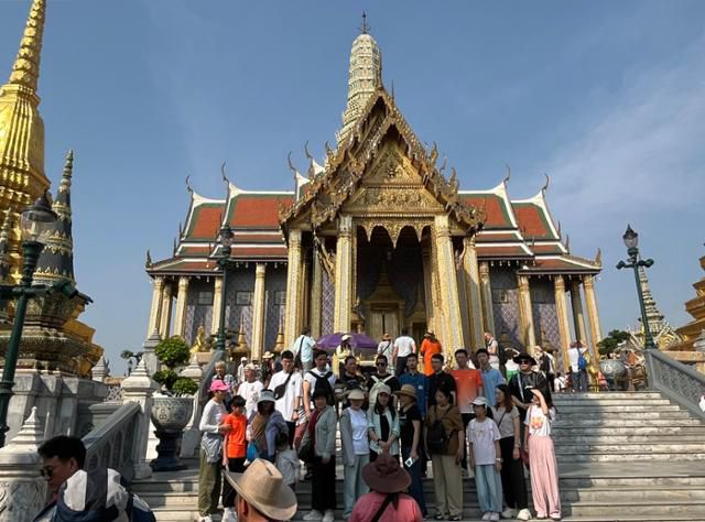 음력 설 기간인 지난달 30일 태국 방콕에서 중국인 관광객 일행이 왕궁을 배경으로 단체사진을 촬영하고 있다. 방콕=허경주 특파원