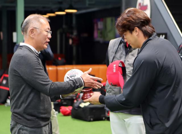 정의선(왼쪽) 현대차그룹 회장이 KIA 타이거즈 주장 나성범 선수로부터 사인볼을 받고 악수를 하고 있다. 현대차그룹 제공