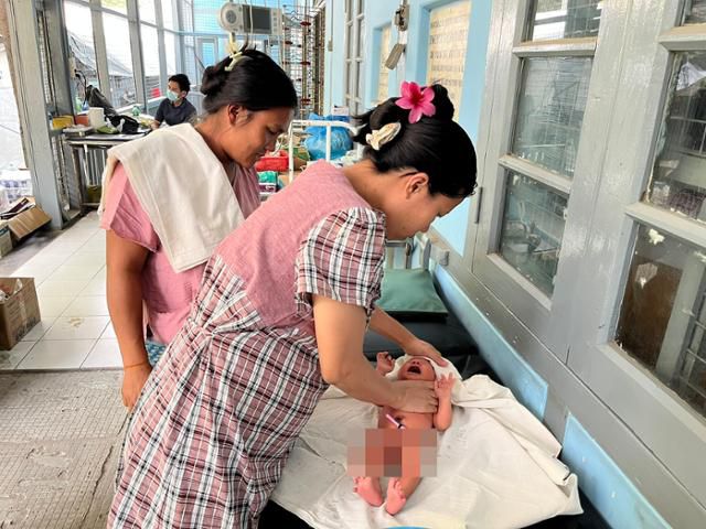 지난 4일 미얀마 만달레이 인근 소도시 아마라푸라의 한 병원에서 산모(오른쪽)가 태어난 지 나흘 된 아기를 씻긴 뒤 속싸개로 감싸고 있다. 아마라푸라=허경주 특파원