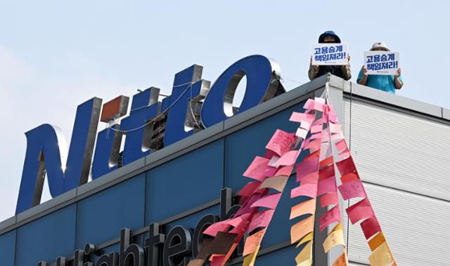 10일 경북 구미시 한국옵티컬하이테크 고공농성장에서 박정혜, 소현숙 노동자가 고용 승계를 요구하는 문구를 들어 보이고 있다. 구미=홍인기 기자