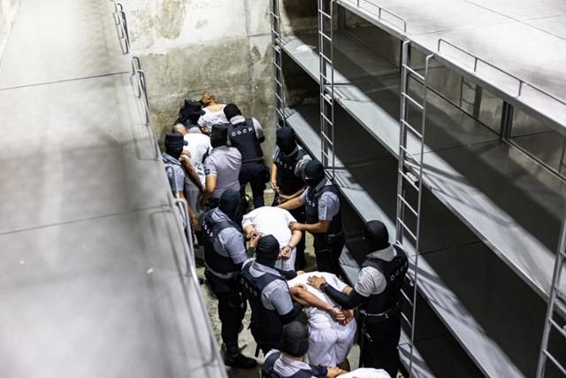 베네수엘라 범죄조직 트렌 데 아라구아 및 MS-13 조직원으로 분류돼 미국에서 추방된 범죄자들이 12일 엘살바도르 테콜루카에 있는 테러감금센터(CECOT)에 수감되고 있다. 테콜루카=로이터 연합뉴스