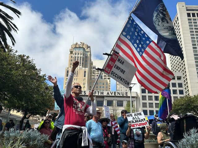 19일 미국 캘리포니아주 샌프란시스코 시내에서 열린 도널드 트럼프 대통령 규탄 시위에서 한 시민이 성조기를 들고 있다. 그의 뒤편에는 한 참가자가 '우리 모두 킬마르다'라고 적힌 팻말을 들고 있다. 샌프란시스코=이서희 특파원