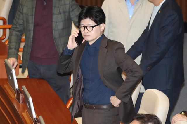 작년 12월 3일 당시 윤석열 대통령이 비상계엄령을 선포한 가운데 4일 새벽 서울 여의도 국회 본회의장에서 한동훈 국민의힘 대표가 심각하게 전화통화를 하고 있다. 뉴스1