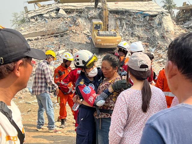 2일 지진 피해를 입은 미얀마 중북부 만달레이의 아파트 붕괴 현장에서 시신이 수습된 희생자의 유가족이 구조 대원을 껴안고 눈물을 흘리고 있다. 만달레이=허경주 특파원