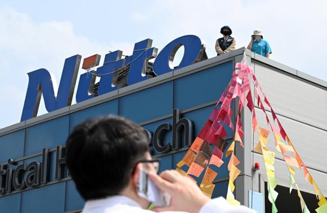 10일 경북 구미시 한국옵티칼하이테크 고공농성장에서 박정혜(왼쪽), 소현숙 노동자가 전화로 건물 아래 기자와 인터뷰를 하고 있다. 구미=홍인기 기자