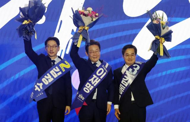 더불어민주당의 제21대 대선 후보로 선출된 이재명(가운데) 전 당대표가 27일 경기 고양시 킨텍스에서 열린 제21대 대통령 선거 후보자 선출을 위한 수도권·강원·제주 합동연설회 도중 함께 후보로 나섰던 김경수(왼쪽) 전 경남지사, 김동연 경기지사와 함께 꽃다발을 들고 인사하고 있다. 뉴시스