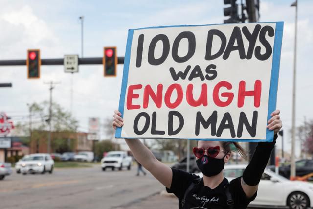 한 시민이 도널드 트럼프 미국 대통령에 반대하는 내용의 팻말을 들고 트럼프 대통령이 도착한 머콤 카운티 커뮤니티 칼리지센터 앞에서 시위를 벌이고 있다. 워런=로이터 연합뉴스