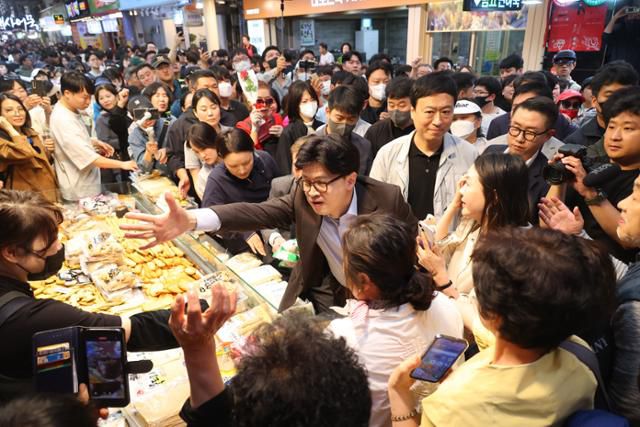 한동훈 전 국민의힘 대표가 2일 부산 중구 부평깡통시장의 한 어묵집에서 상인, 시민들과 인사하고 있다. 부산=연합뉴스